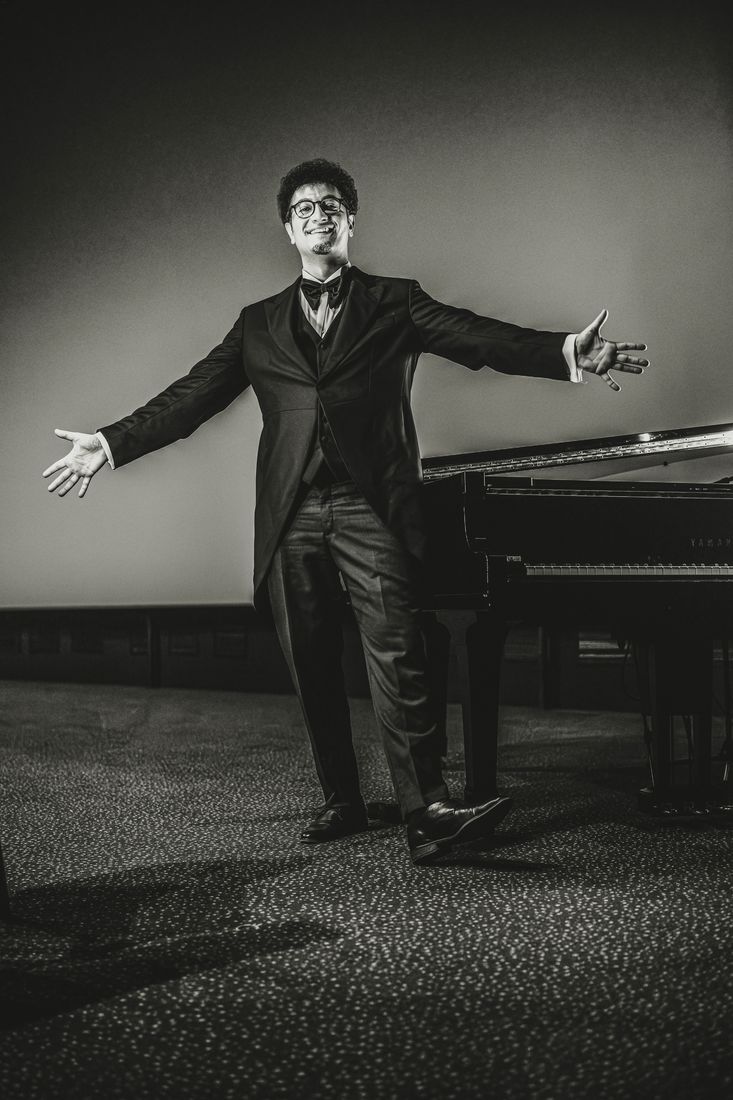 Samvel, bras ouverts devant le piano